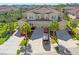 Aerial view of townhomes with well-maintained lawns, driveways, landscaping, and Mediterranean-style tile roofs at 8323 Enclave Way # 104, Sarasota, FL 34243