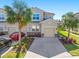 Charming two-story home featuring a well-manicured lawn, mature palm trees, and a neutral color scheme at 8323 Enclave Way # 104, Sarasota, FL 34243