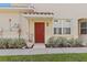 Inviting front door with red trim and landscaped bushes, perfect for a warm welcome at 8323 Enclave Way # 104, Sarasota, FL 34243