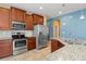 Well-lit kitchen boasts stainless appliances, granite counters, and wooden cabinetry at 8323 Enclave Way # 104, Sarasota, FL 34243