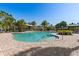 Large community pool area, equipped with palm trees, lounge chairs, and shaded seating areas for resident relaxation at 8323 Enclave Way # 104, Sarasota, FL 34243