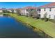 Lush landscaping with pond views for a tranquil living experience with a tiled roof at 8323 Enclave Way # 104, Sarasota, FL 34243