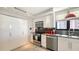 Modern kitchen featuring stainless steel appliances, gray backsplash and white cabinetry at 97 Sunset Dr # 203, Sarasota, FL 34236