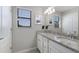 Bright bathroom featuring a double vanity with granite countertops, framed mirrors, and white cabinets at 10905 Copperlefe Dr, Bradenton, FL 34212