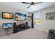 This sports-themed room has mounted TVs, a ceiling fan, and a leather couch for the ultimate fan experience at 10905 Copperlefe Dr, Bradenton, FL 34212
