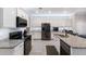 Modern kitchen featuring stainless steel appliances, granite countertops, and white cabinetry at 10905 Copperlefe Dr, Bradenton, FL 34212