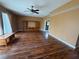 Open-concept living room features ceiling fan, wood floors, and custom built-in cabinets at 11120 Sailbrooke Dr, Riverview, FL 33579