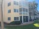 Multi-story building with screened-in lanais, lawn and shrubbery on a sunny day at 1257 S Portofino Dr # 208, Sarasota, FL 34242