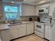 Bright kitchen with white appliances, ample counter space, and a view of the outdoors at 1257 S Portofino Dr # 208, Sarasota, FL 34242