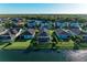 Back aerial view of homes with screened patios overlooking the community lake and mature landscaping at 13228 Saw Palm Creek Trl, Lakewood Ranch, FL 34211