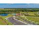 Scenic aerial view of community with lake, clubhouse, parking, playground, and manicured landscaping at 13228 Saw Palm Creek Trl, Lakewood Ranch, FL 34211