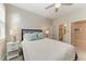 Comfortable bedroom features a queen-sized bed, ceiling fan, bedside table and ensuite bathroom at 13228 Saw Palm Creek Trl, Lakewood Ranch, FL 34211