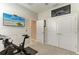 Bonus bedroom with a Peloton exercise bike, mounted TV, and closet storage at 13228 Saw Palm Creek Trl, Lakewood Ranch, FL 34211