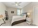 Well-lit bedroom with ceiling fan, a writing desk, bedside table and a queen-sized bed at 13228 Saw Palm Creek Trl, Lakewood Ranch, FL 34211