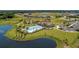 Overhead view of a community pool and clubhouse surrounded by palm trees, lush lawns, and walking trails near a pond at 13228 Saw Palm Creek Trl, Lakewood Ranch, FL 34211
