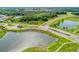 Scenic aerial shot of the community entrance with lush landscaping, a tranquil pond, and meticulously maintained grounds at 13228 Saw Palm Creek Trl, Lakewood Ranch, FL 34211