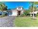 Beautiful single-story home featuring a tile roof, stone accents, manicured landscaping, and a brick-paved driveway at 13228 Saw Palm Creek Trl, Lakewood Ranch, FL 34211