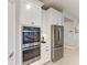 Modern kitchen with stainless steel appliances, double ovens, and sleek white cabinetry at 13228 Saw Palm Creek Trl, Lakewood Ranch, FL 34211
