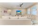 Inviting living space with plush sofa, sleek ceiling fan, and ample natural light from large windows at 13228 Saw Palm Creek Trl, Lakewood Ranch, FL 34211