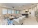 Spacious living room with tile flooring, large windows, ceiling fan, and an open concept design at 13228 Saw Palm Creek Trl, Lakewood Ranch, FL 34211