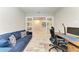 Inviting office with comfortable sofa, desk, and sliding doors, perfect for working from home at 13228 Saw Palm Creek Trl, Lakewood Ranch, FL 34211