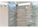 Beautiful glass enclosed shower features stylish tile, shower head, and convenient shelving at 13228 Saw Palm Creek Trl, Lakewood Ranch, FL 34211