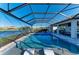 The screened-in lanai features a swimming pool, spa, and two lounge chairs with relaxing lake views at 13228 Saw Palm Creek Trl, Lakewood Ranch, FL 34211