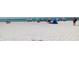 Expansive white sand beach with crystal clear blue ocean water and beachgoers relaxing under colorful umbrellas at 1412 56Th W St # 1412, Bradenton, FL 34209