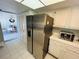 The kitchen offers stainless steel refrigerator and leads to a dining area with white cabinets at 1412 56Th W St # 1412, Bradenton, FL 34209