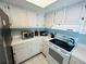 Bright kitchen showcasing white cabinets, countertops, and appliances, with tile flooring for easy maintenance at 1412 56Th W St # 1412, Bradenton, FL 34209