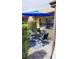 Outdoor patio featuring a dining table with chairs under a blue umbrella and lush landscaping at 1412 56Th W St # 1412, Bradenton, FL 34209