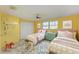 Charming ' bedroom with two beds, yellow walls, and playful decor at 1550 Royal Rd, Venice, FL 34293