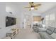 Bright living room with ceiling fan, built-in cabinets and TV, offering comfortable living at 203 Casa Del Lago Way # 203, Venice, FL 34292