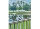 A balcony view showcasing a serene pond surrounded by lush green grass and mature trees at 2060 Willow Hammock Cir # 201, Punta Gorda, FL 33983