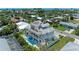 Aerial view of a luxurious three-story home with a rooftop terrace, pool, and lush landscaping, embodying coastal elegance at 215 83Rd St, Holmes Beach, FL 34217