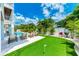Relaxing backyard with lounge chairs, putting green, and lush tropical landscaping creating the perfect outdoor retreat at 215 83Rd St, Holmes Beach, FL 34217