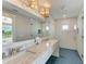 Sleek bathroom featuring a double vanity, blue tile flooring, and a glass shower with a tropical view at 215 83Rd St, Holmes Beach, FL 34217