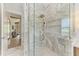 Modern bathroom shower with glass enclosure, marble tiling, rain shower head, and built-in shelving at 215 83Rd St, Holmes Beach, FL 34217