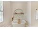 Elegant soaking tub with bronze fixtures and a built-in niche for decor, creating a serene bathing space at 215 83Rd St, Holmes Beach, FL 34217
