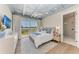 Serene bedroom featuring tray ceiling, balcony access with scenic views, and ensuite bathroom at 215 83Rd St, Holmes Beach, FL 34217