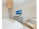 Serene bedroom showcasing a neutral color scheme, a decorative chandelier, and a large TV for ultimate relaxation at 215 83Rd St, Holmes Beach, FL 34217