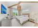Comfortable bedroom featuring beamed ceilings, an elegant chandelier, large windows, and neutral decor for a relaxing space at 215 83Rd St, Holmes Beach, FL 34217