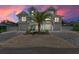Stunning two-story coastal home with a lush palm tree and a paver driveway, capturing serene beachside living at 215 83Rd St, Holmes Beach, FL 34217