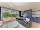 Bright living room featuring a stylish leather sofa, blue built-ins, and a sliding glass door to the outside deck at 215 83Rd St, Holmes Beach, FL 34217