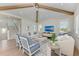 Cozy living room with vaulted ceiling, wood beams, and stylish seating next to the staircase at 215 83Rd St, Holmes Beach, FL 34217