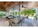 Expansive outdoor kitchen and lounge area under a wood ceiling, complete with a grill, dining table, and plush seating at 215 83Rd St, Holmes Beach, FL 34217