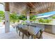 Covered outdoor kitchen and dining area with modern grill and a full dining table, perfect for al fresco dining at 215 83Rd St, Holmes Beach, FL 34217