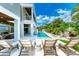 Resort-style pool with lush landscaping, lounge chairs, and a covered lanai provides ultimate outdoor relaxation at 215 83Rd St, Holmes Beach, FL 34217