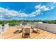 The rooftop deck with ample seating provides a stunning view of the surrounding trees and blue skies at 215 83Rd St, Holmes Beach, FL 34217