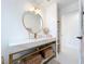 Bathroom featuring a modern vanity, gold fixtures, and a round mirror with decorative lighting at 2308 Tulip St, Sarasota, FL 34239